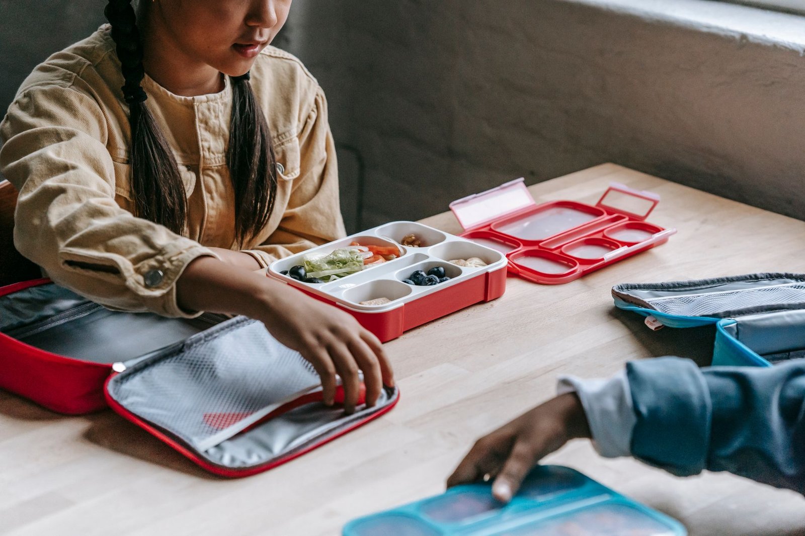 A 3-compartment kids bento lunch box with a balanced meal prepared for school.