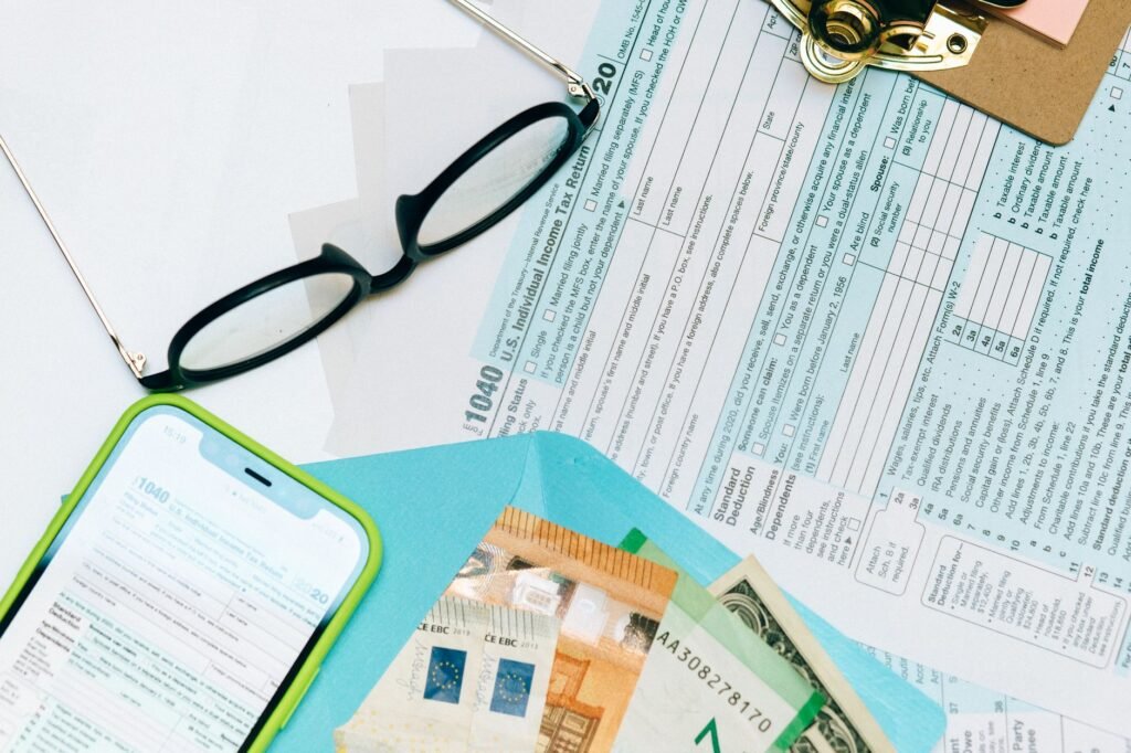 A person reviewing Venmo and PayPal transactions on a smartphone next to a 1099-K tax form and a calculator. practical detail