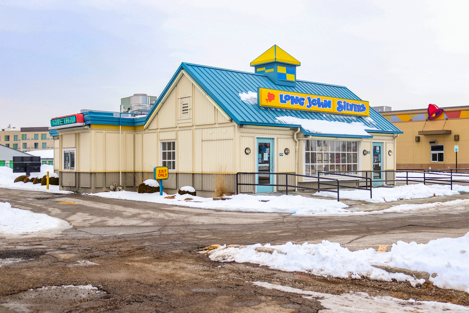 A Long John Silver's style building with a closed sign during sunset