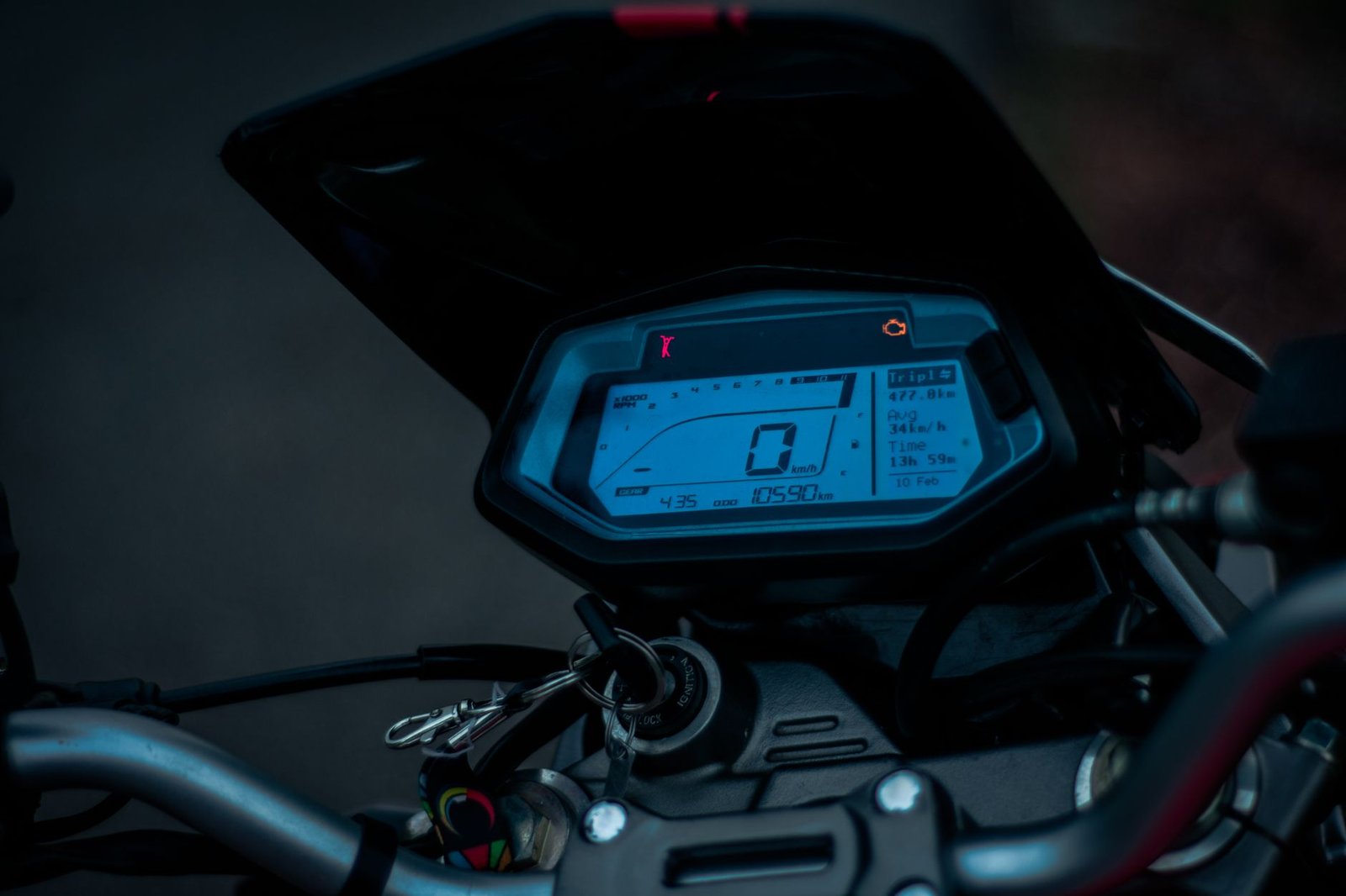 Close-up of a person applying a screen protector to a motorcycle digital dashboard.