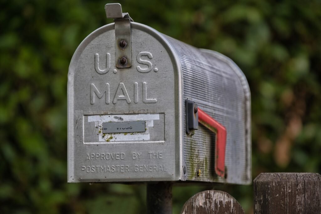 A USPS mail collection box with mail-in ballots being deposited during the 2026 election cycle. practical detail
